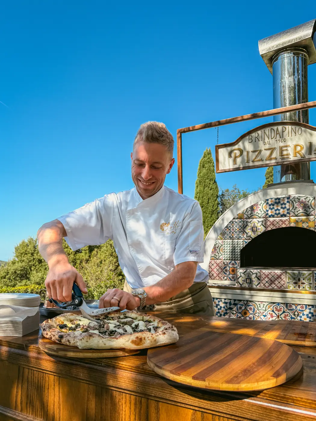Marco Manzi inforna una pizza nel forno in maiolica durante un evento
