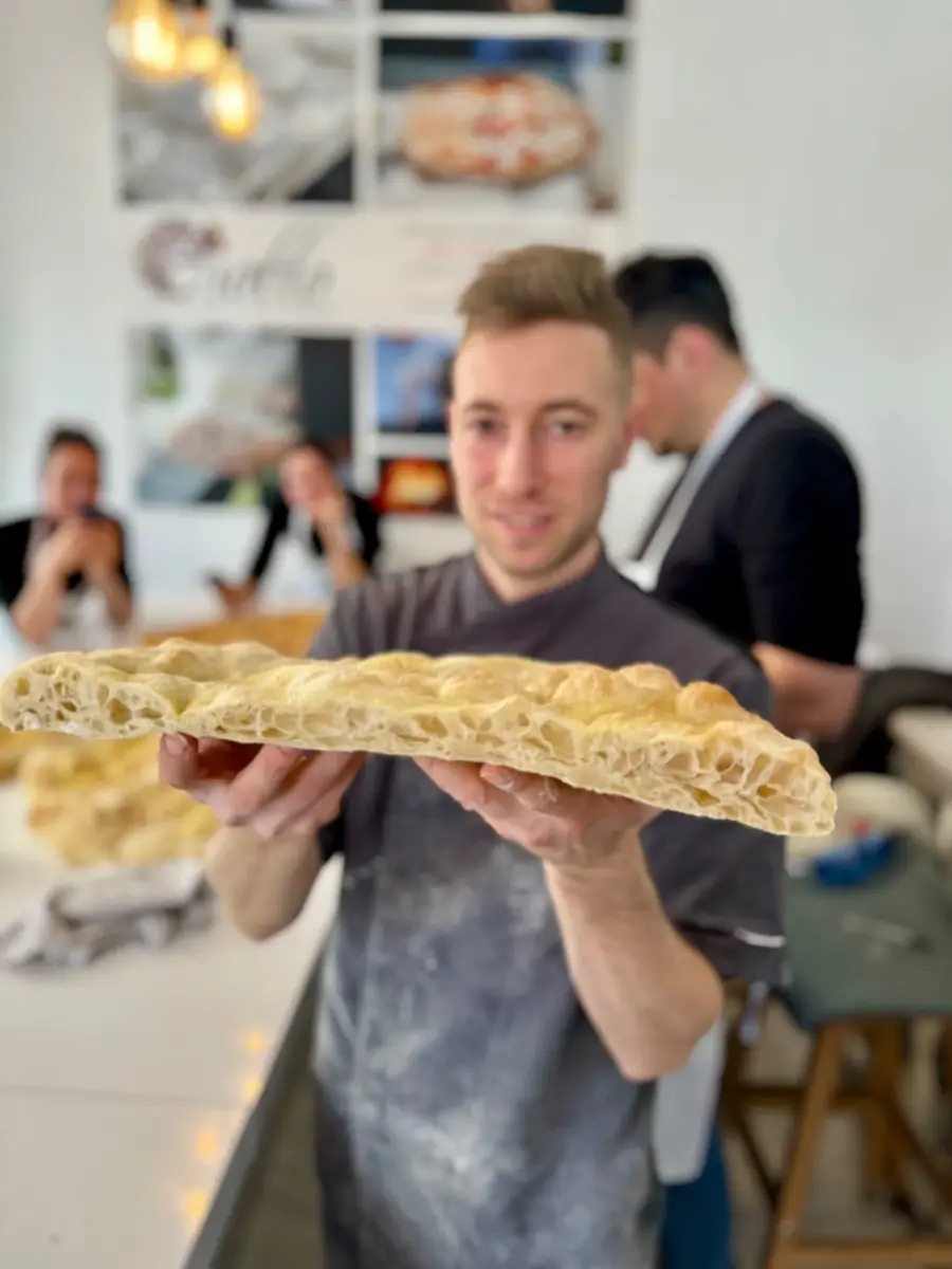 Un corsista con una pizza in teglia
